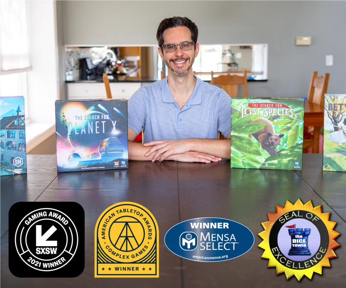 Ben Rosset sitting behind several of his award winning games